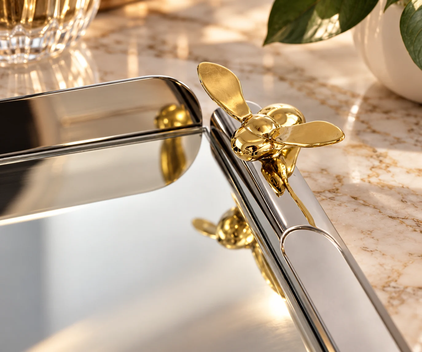 Ornement abeille doré et reflets sur un plateau miroir